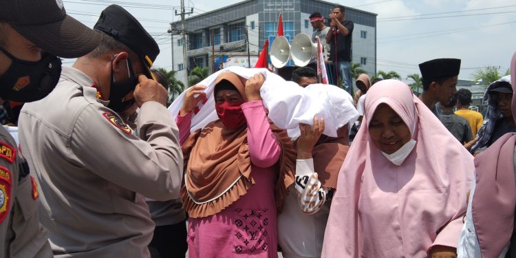 Ketgam: Emak-emak menggelar aksi unjuk rasa di Mapolda Sultra tuntuk pembebas 3 warga yang ditangkap dan penolakan PT GKP. Foto: Herlis