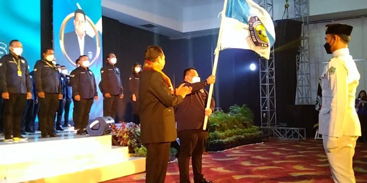 Ketgam: Anton Timbang mengibarkan bendera IMI Sultra sesaat setelah pelantikan. Foto: Herlis
