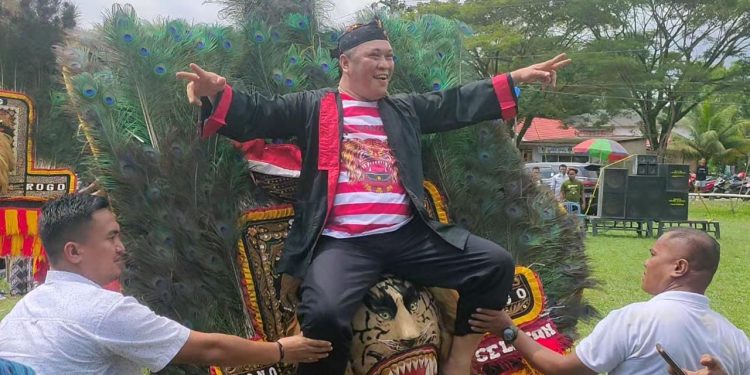 Ketgam:  Bupati Konut tampak menikmati suasana, ia bahkan menaiki kepala singa bersama beberapa penari lainnya, Minggu (15/5/2022). Foto: Herlis Ode Mainuru