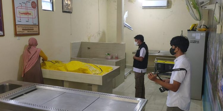Ketgam : Lusiana saat mengechek jenazah ibunya di ruang jenazah Rumkit Bhayangkara Kendari. Foto: Herlis