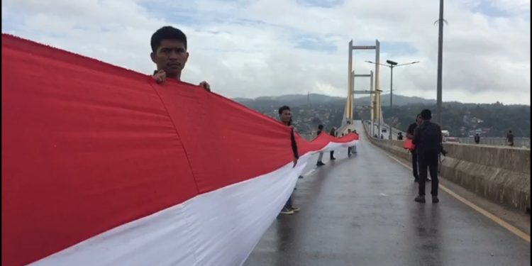 Ketgam: Suasana pengibaran Bendera Merah Putih sepanjang 770 di Jembatan Teluk Kendari. Foto: Herlis