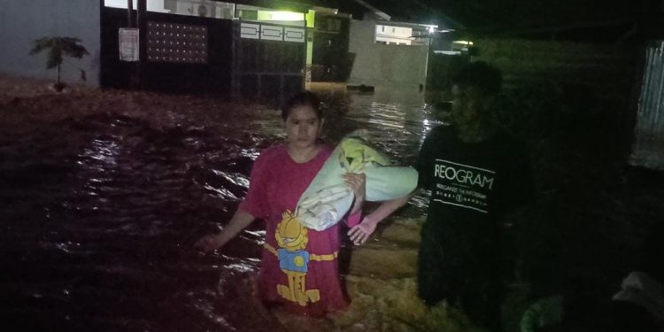 Warga menyelamatkan diri dari kepungan banjir di BTN Puri Indah