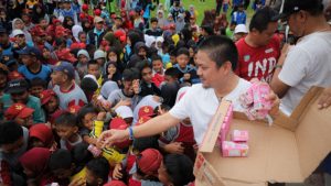 Bupati Kolaka Timur, Abd Azis, membagikan susu kepada para pelajar saat pembukaan O2SN, FLS3N, serta GSI di lapangan sepak bola Desa Gunung Jaya, Kecamatan Dangia, Jumat (11/7/2025). (Foto: Istimewa)